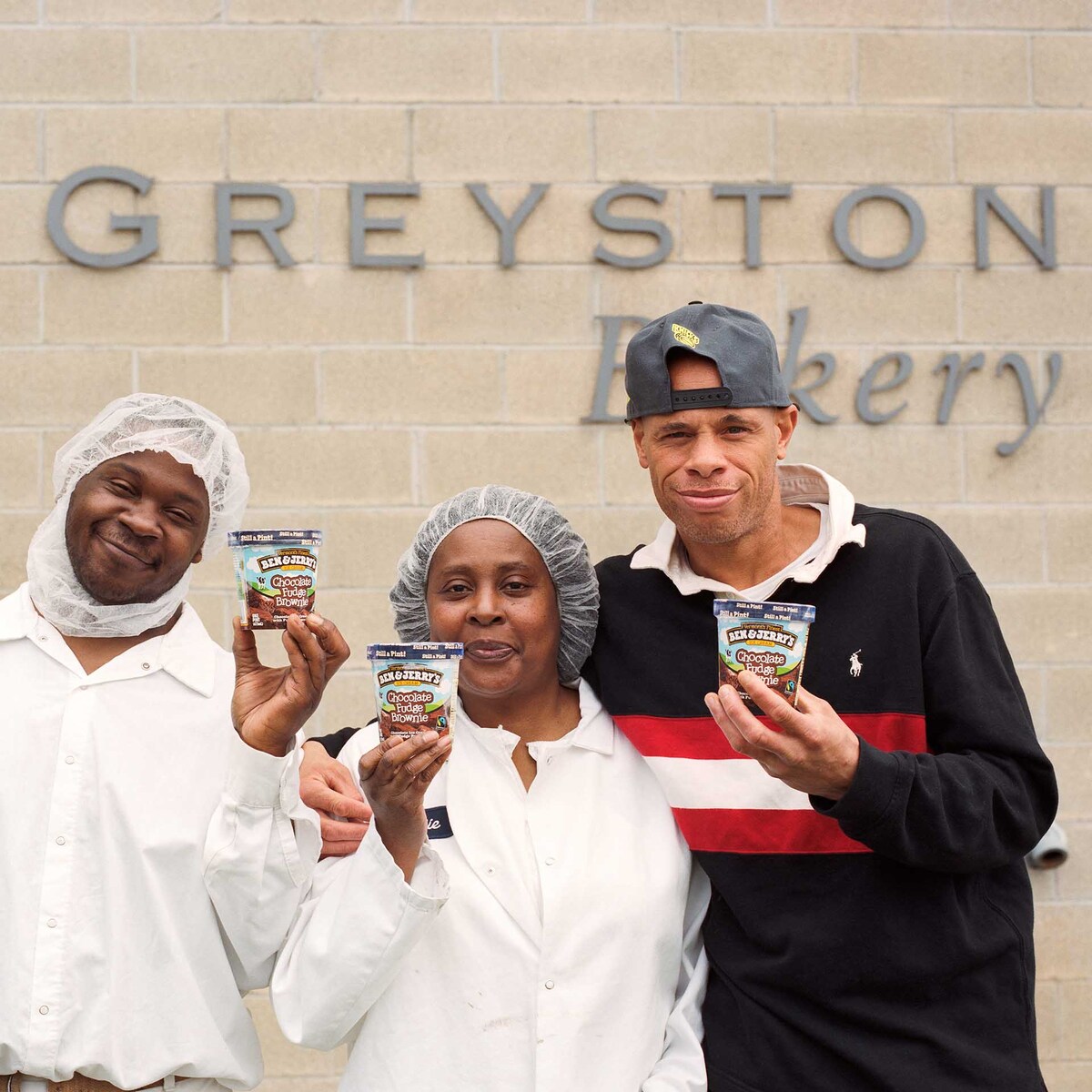 Mitarbeiter der Greyston Bakery halten Eiscremebecher von Ben & Jerry’s